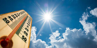 Thermometer stretches into a sunny sky indicating high heat