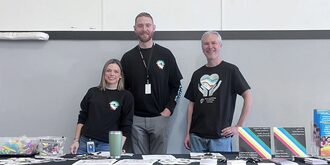 Three staff wearing black shirts with DD logo