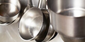stainless steel pots and pans hang in restaurant kitchen