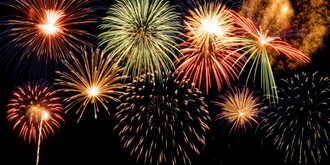 A dark night sky lit up with gold and green fireworks