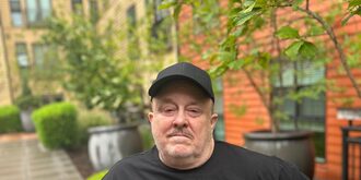Kevin standing outside of his home