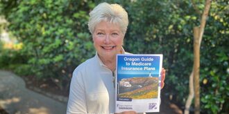 Smiling woman holds Medicare guide