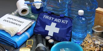 First aid kit, bottled water, flashlight and an assortment of other supplies in an emergency kit