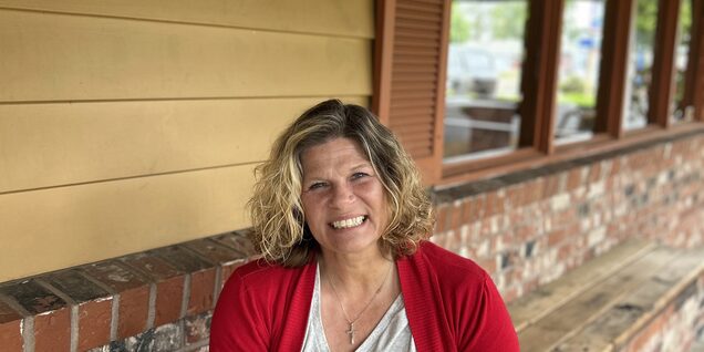 A picture of Erica sitting on a bench in front of shelter