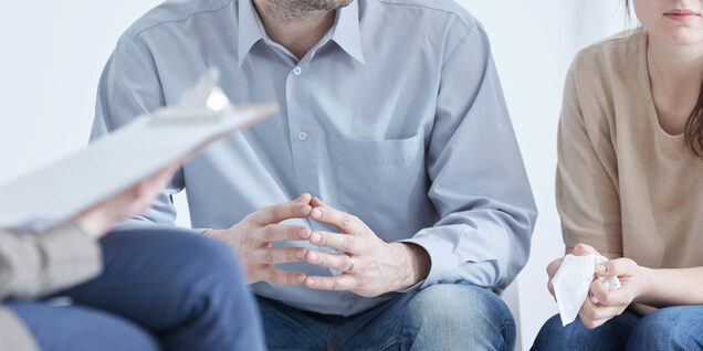 Picture of a white couple meeting with a third person holding papers