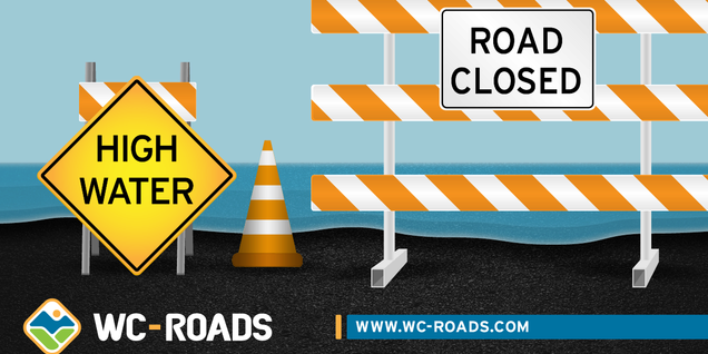 Barricade and signs that say "High Water" and "Road Closed"
