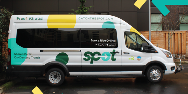 SPOT microtransit passenger van style shuttle. It's white with the SPOT logo and yellow, green and aqua colored polka-dots. Catchthespot.com is printed on the side.