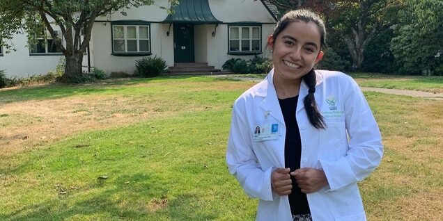 Smiling young woman in lab coat
