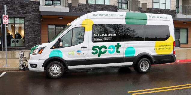 The SPOT shuttle van which is white with yellow, green and aqua polka dots sits in its dedicated pick up parking spot at Amity Orchards