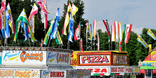 Top banners of funnel cakes, sno cones, drinks, and pizza food carts at a festival or fair.