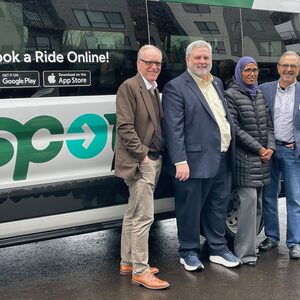 Washington Couty Leaders---Land Use & Transportation Director Stephen Roberts and -County Commissioners Jason Snider, Nafisa Fai, and Jerry Willey smiling as they stand next to the SPOT shuttle.