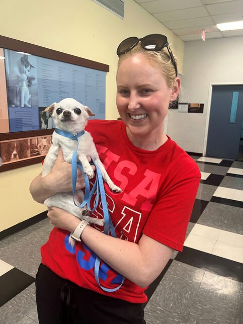 Smiling woman holding a cute little chihuahua