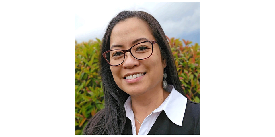 A woman with black hair wearing glasses and a collared t-shirt under a black blazer. r a 