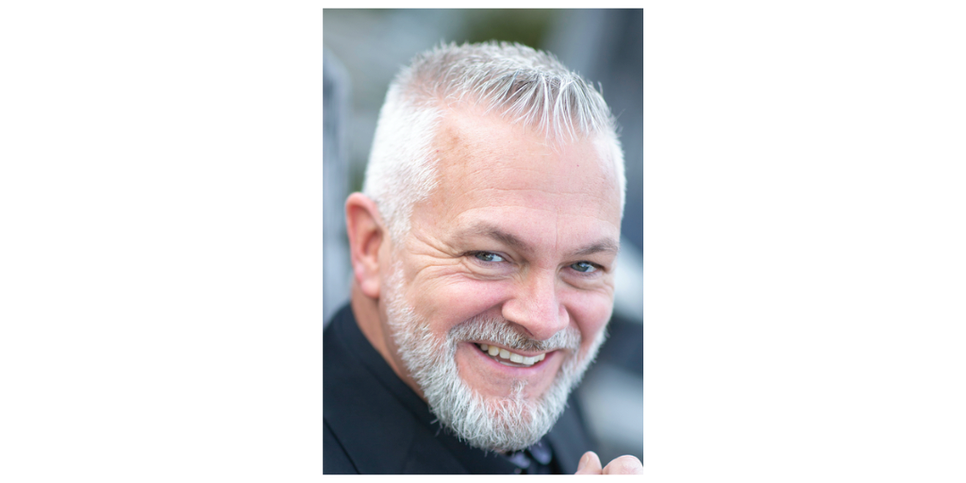 A man with white hair and black shirt. 